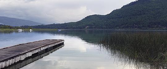 Logan State Park - Wooden dock extending into a calm lake surrounded by forested hills.